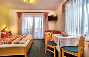 Habitación de hotel con cama, mesa y sillas en Komfort- & Wellnesspension Rehwinkel, en Bodenmais