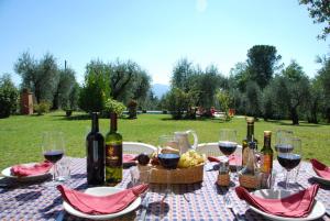 ValgianoにあるCasa Tonio by Salogi Villasのワインボトルとブドウのバスケット付きのテーブル