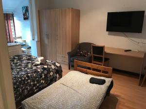 a bedroom with two beds and a tv and a chair at Apartment Zaventem Brussels Airport D in Zaventem