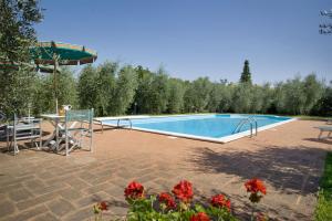 una piscina con mesa, sillas y flores en Villa La Fonte, en Palaia