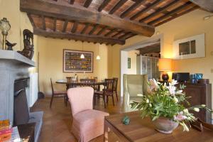 a living room with a fireplace and a dining room at Villa La Macchietta in Monsagrati