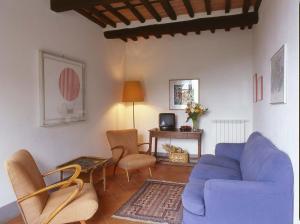 a living room with a blue couch and chairs at Villa Magrini in San Gennaro