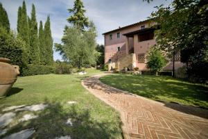 einen Backsteinweg, der zu einem großen Haus führt in der Unterkunft Villa Le Rondini in Montopoli in Val dʼArno