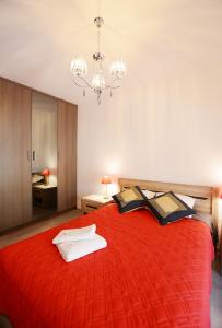 a bedroom with a large red bed with a chandelier at Apartament Polanki Park-kryty basen in Kołobrzeg