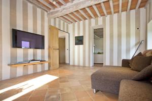 a living room with a couch and a flat screen tv at La Maccinaia by Salogi Villas in Monte Benichi