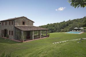 an external view of a house with a swimming pool at La Maccinaia by Salogi Villas in Monte Benichi