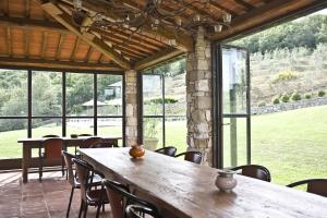 ein Esszimmer mit Tischen, Stühlen und Fenstern in der Unterkunft Villa La Maccinaia in Monte Benichi