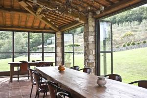 a dining room with tables and chairs and windows at Villa La Maccinaia in Monte Benichi