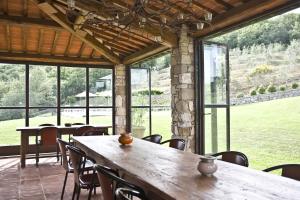 a dining room with tables and chairs and windows at La Maccinaia by Salogi Villas in Monte Benichi