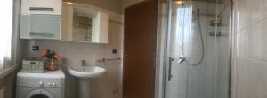 ペスキエーラ・デル・ガルダにあるKARINA'S homeのバスルーム(シャワー、シンク、洗濯機付)
