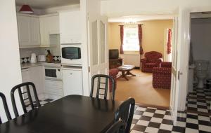 a kitchen and living room with a table and chairs at Riverside Holiday Homes in Aughrim