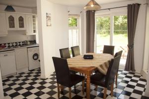 a kitchen and dining room with a table and chairs at Riverside Holiday Homes in Aughrim