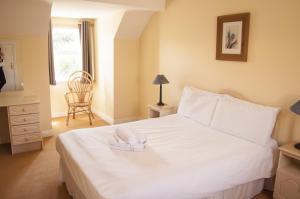 a bedroom with a white bed with a towel on it at Riverside Holiday Homes in Aughrim