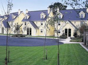a large house with a lawn in front of it at Riverside Holiday Homes in Aughrim