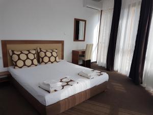 una camera da letto con un grande letto con asciugamani di Yuliya Guest House a Sapareva Banya