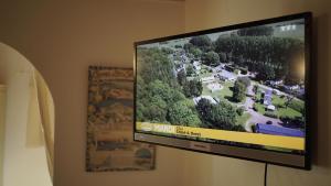 telewizor z płaskim ekranem wiszący na ścianie w obiekcie La Maison des Oliviers w mieście Cogolin