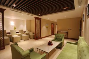 a waiting room with green chairs and a table at FLC Luxury Resort Vinh Phuc in Hoằng Xá