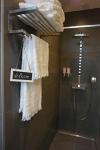 ein Bad mit Dusche und ein Schild mit der Aufschrift Melalor in der Unterkunft B&B Sixteen in Brügge