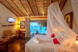 a bedroom with a bed with a mosquito net at Secret Garden Beach Resort in Bangrak Beach