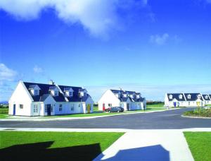 a row of houses with a car parked in the driveway at Ballybunion Holiday Cottages in Ballybunion