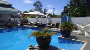 - une piscine avec des plantes en pot sur une terrasse dans l'établissement Le Bonheur Villa, à Victoria