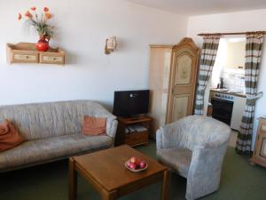 a living room with a couch and a chair at Fewo am Skihang / Bergwiese in Missen-Wilhams