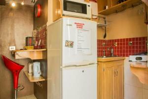 uma cozinha com um micro-ondas em cima de um frigorífico em One32 Guesthouse Red Velvet em Kingston