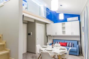 una sala da pranzo con tavolo e sedie bianchi di Suite Bordonaro Apartments a Cefalù