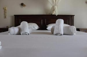 a bed with rolled towels on top of it at Avra Studios in Elafonisos