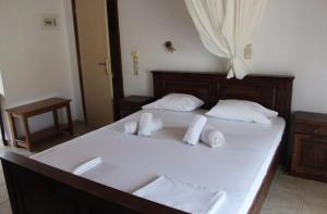 a large white bed with white pillows on it at Avra Studios in Elafonisos