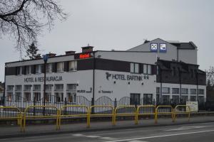un edificio blanco con un cartel en el costado en Hotel Bartnik, en Pszczółki