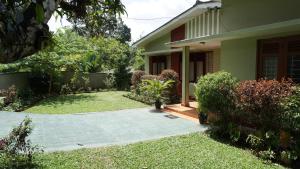 a house with a walkway in front of a yard at Jayawimana in Kandy