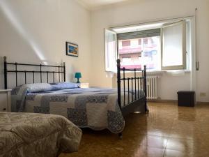 1 Schlafzimmer mit 2 Betten und einem Fenster in der Unterkunft Romolo House in Rom