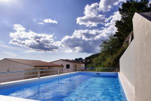 a swimming pool on the side of a house at Villa Palloma in Baška Voda