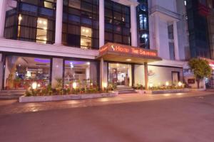 un magasin devant un bâtiment la nuit dans l'établissement Hotel The Sojourn, à Kolkata