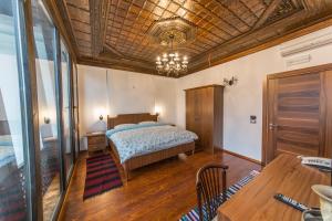 a bedroom with a bed and a wooden ceiling at Hotel Onufri in Berat