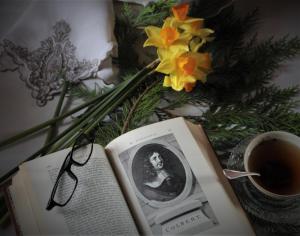 a book and glasses on a table with a cup of coffee at Angoville44 in Angoville-au-Plain