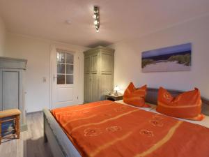 ボルテンハーゲンにあるClassy Apartment in Boltenhagen with Terraceのベッドルーム1室(大型ベッド1台、オレンジ色の枕付)