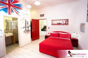 a bedroom with a red bed and a bathroom at ToledoStation B&B in Naples