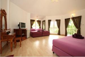 a bedroom with a bed and a couch and a desk at Nimmanoradee Resort - SHA PLUS Certified in Ko Samed