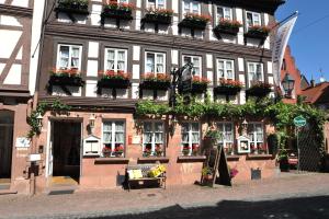 un bâtiment avec des boîtes de fleurs sur son côté dans l'établissement Wein-und Gasthof Zipf, à Miltenberg