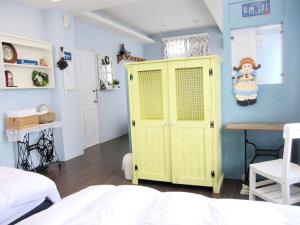 1 dormitorio con armario amarillo y mesa en Sweet Home 101, en Guangfu