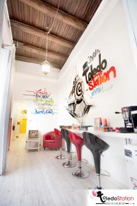 un salon de coiffure avec des chaises rouges et des panneaux sur le mur dans l'établissement ToledoStation B&B, à Naples