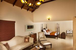 a living room with a couch and a bed at Old Kent Estates & Spa, Coorg in Suntikoppa