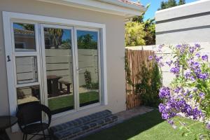un jardín con ventana y flores púrpuras en Hamilton Garden Suites en Parklands