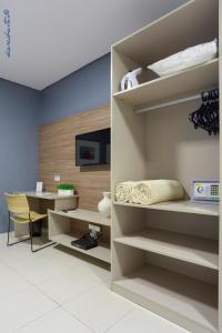 a room with a desk and a book shelf at Portofino Hotel Prime in Teresina