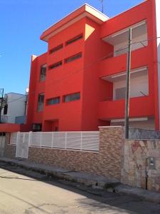 un edificio rojo al lado de una calle en Monolocali Angelica, en Porto Cesareo