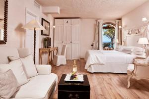 a living room with a bed and a couch at La Villa Del Re - Adults Only - Small Luxury Hotels of the World in Castiadas