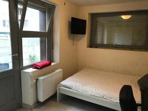 a small bedroom with a bed and a window at Apartment Zaventem Brussels Airport G in Zaventem