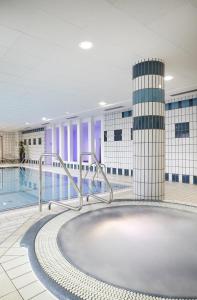 a large swimming pool in a building at Hôtel Spa Du Béryl in Bagnoles de l'Orne